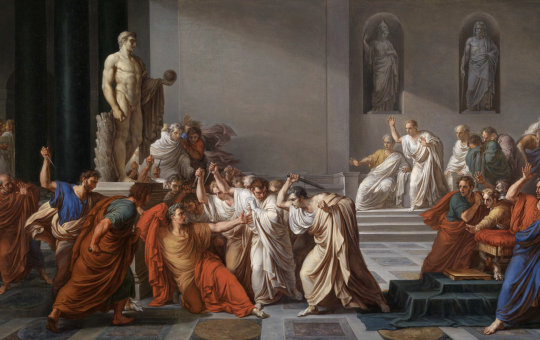 Several senators surround Julius Caesar with knives.